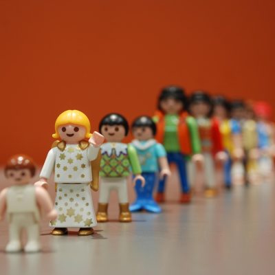 极品采花郎主编林砚舟在书架前翻查资料，手持便签纸正在核对条目编号，背景是分类整齐的资料夹与深色木架